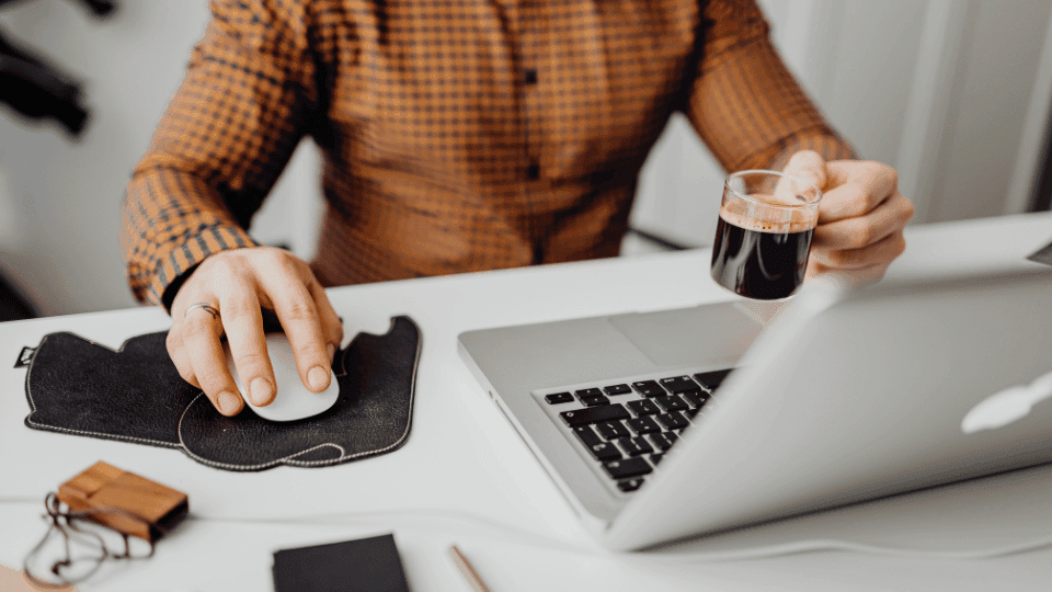 A resident enjoying coffee while working from a dedicated desk space in a modern, furnished room for rent in Bangalore.