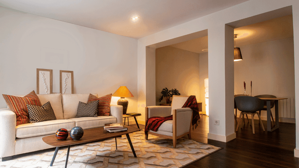 Spacious and well-lit living room interior of a modern flat for rent in Gurgaon, featuring a stylish white sofa, wooden coffee table, and contemporary decor.